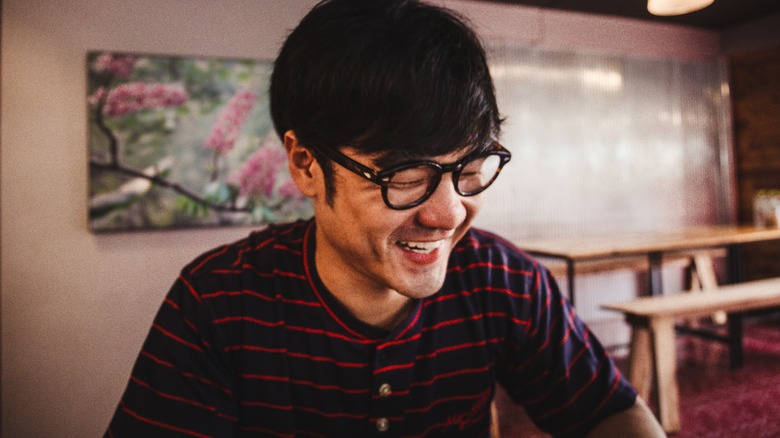 Dark-haired man in cafe laughing