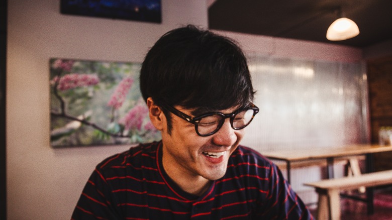 Man seated at table laughing