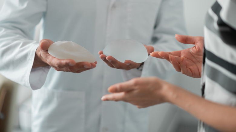 Doctor holding breast implants