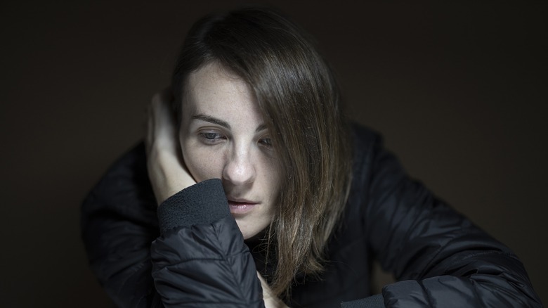 Woman with her head on her arms leaning down on a table