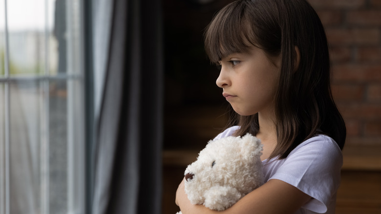 child alone looking out window