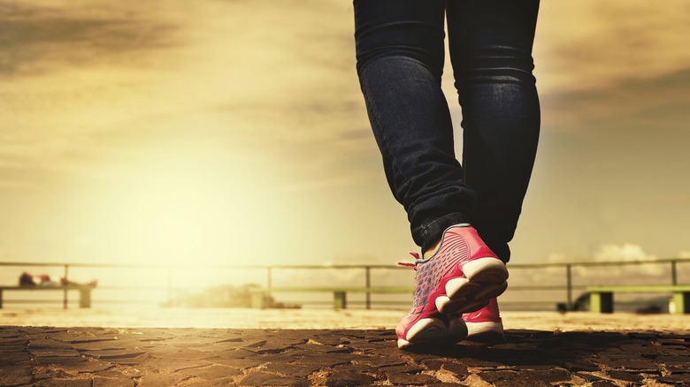 Person wearing running shoes walking outside