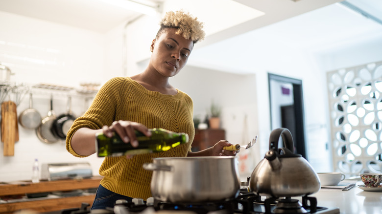 Woman cooking with olive oil