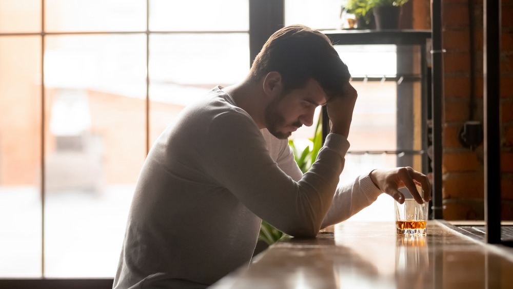 man drinking at bar alone