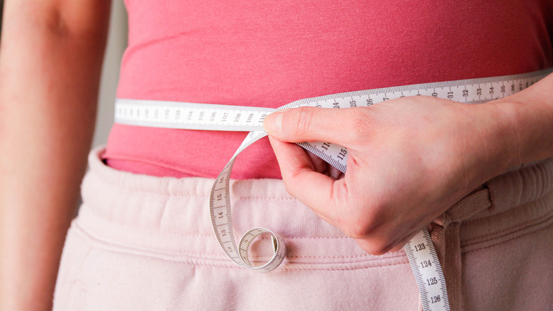 woman measuring her waist circumference