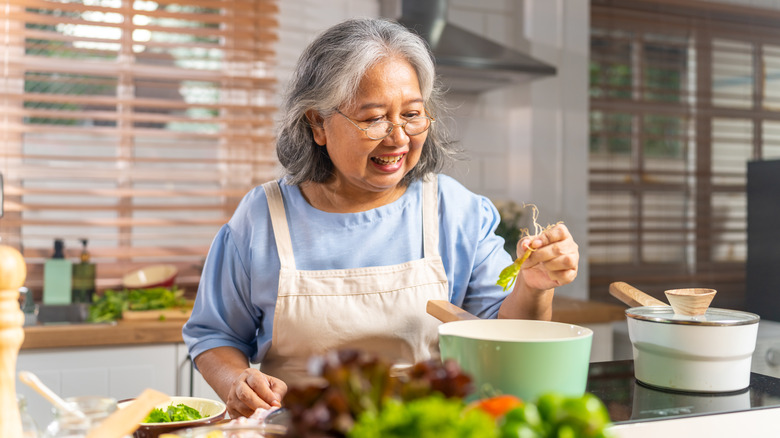 older woman making chicken bone broth at home