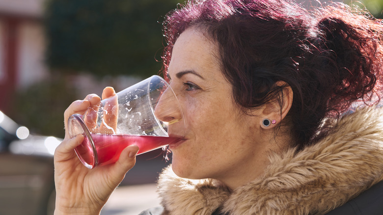 woman outside drinking berry juice