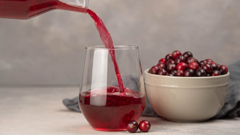 cranberry juice being poured into a glass