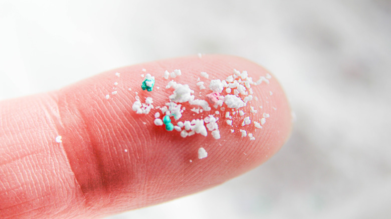 A close-up of microplastic on someone's finger