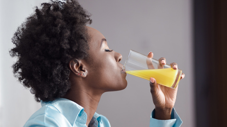 woman drinking orange juice