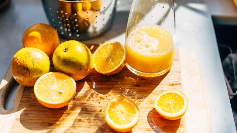 sliced oranges next to a pitcher of orange juice