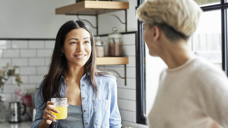 woman in her kitchen drinking orange juice