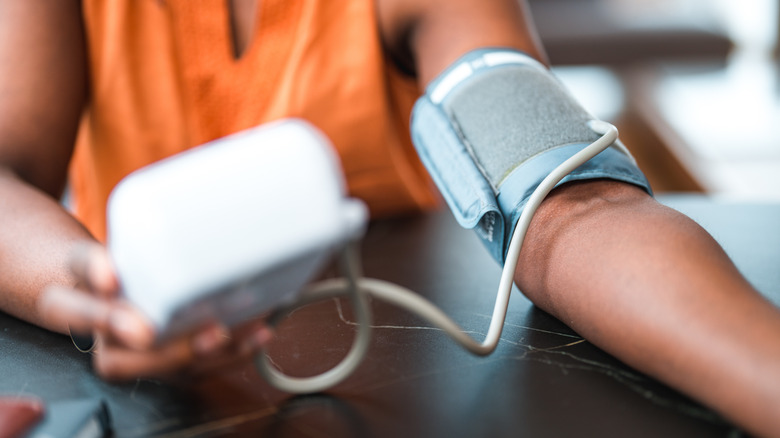 Hands using blood pressure machine