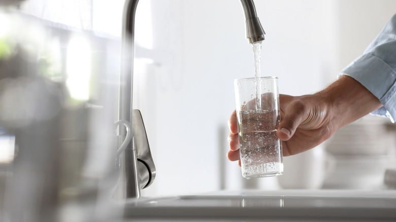 man pouring water into glass