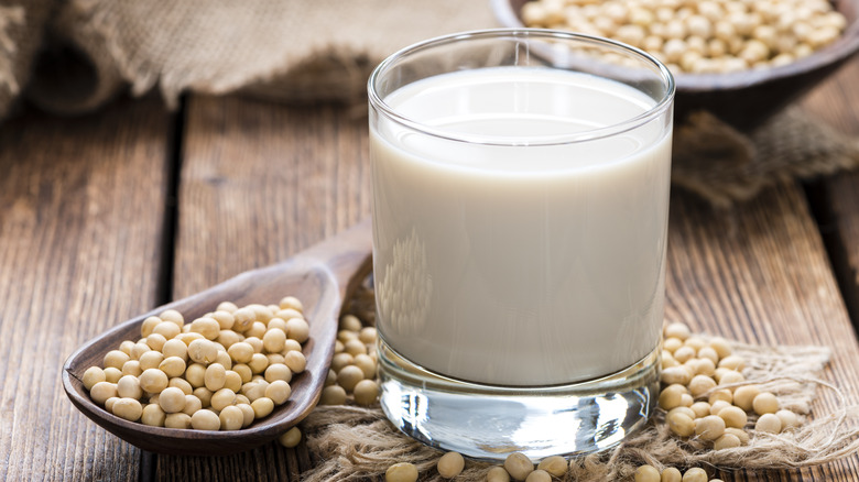 Glass of soy milk by soy seeds