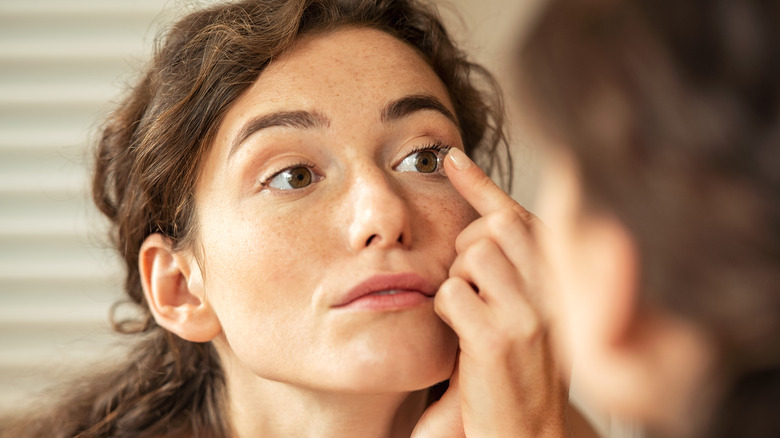 Woman putting in contacts