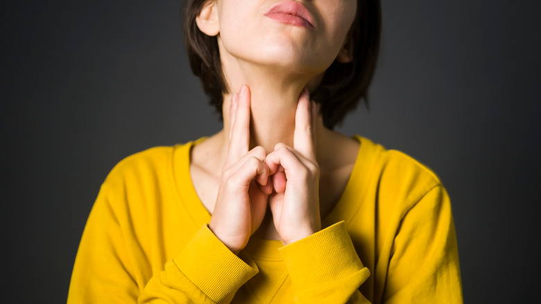 Woman checks thyroid gland