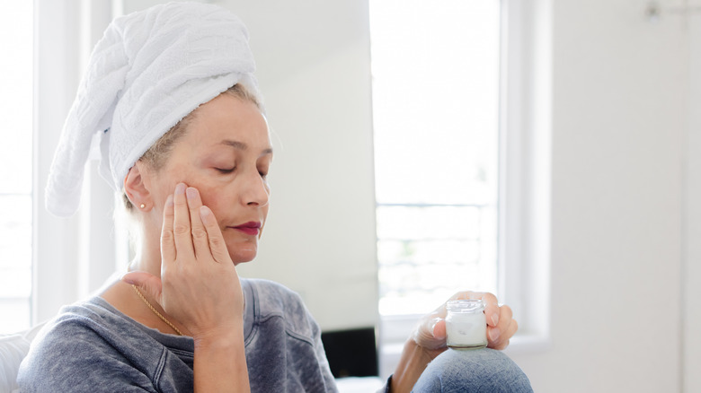 Older woman applying face cream