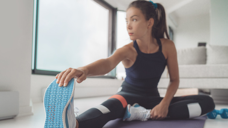 woman stretching on yoga mat