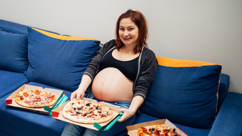 Pregnant women with lots of pizza.