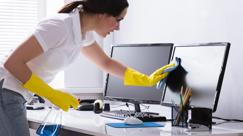 woman cleaning computer monitors