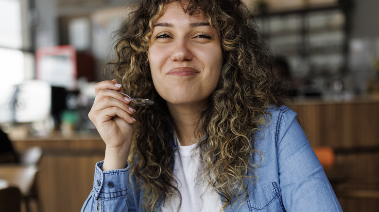 Smiling woman holding spoon