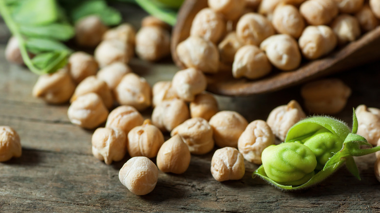 Close up of chickpeas on a wooden table and in a wooden scoop