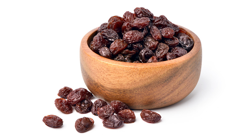 Black raisins in wooden bowl