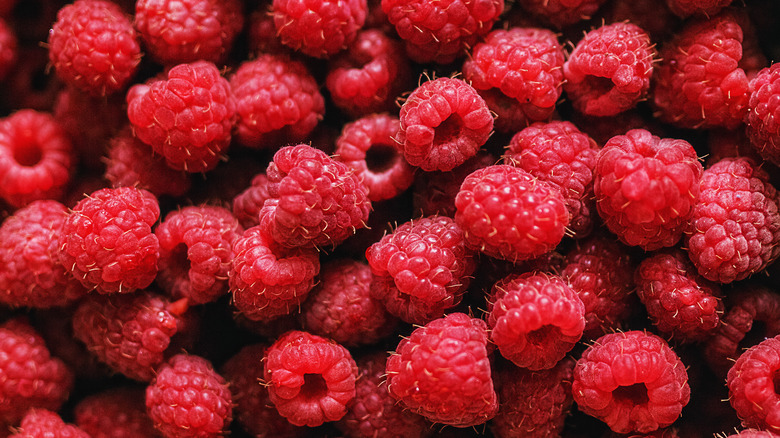 Close up of red raspberries piled on top of one another