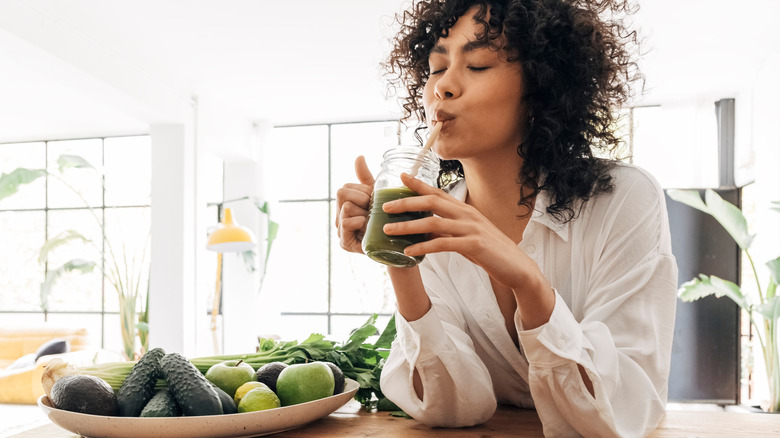 young woman drinking green smoothie