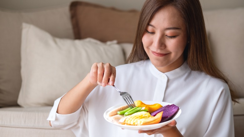 woman eating healthy foods in her living room