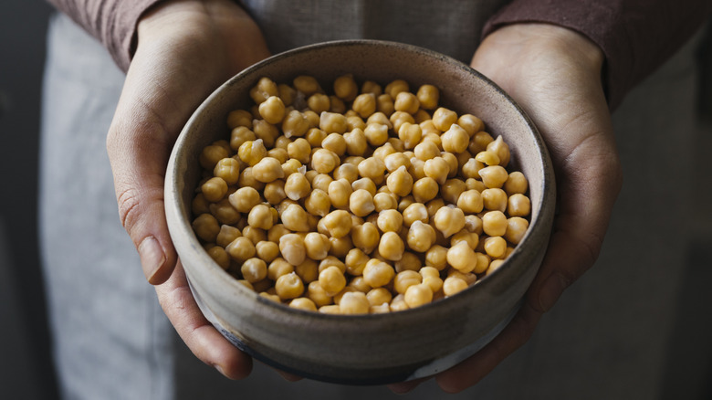 woman's hands holding a bowl of chickpeas