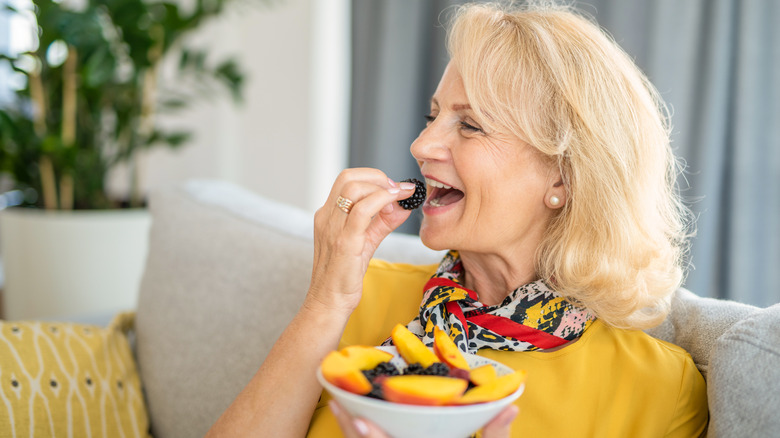 woman eating berries and peaches