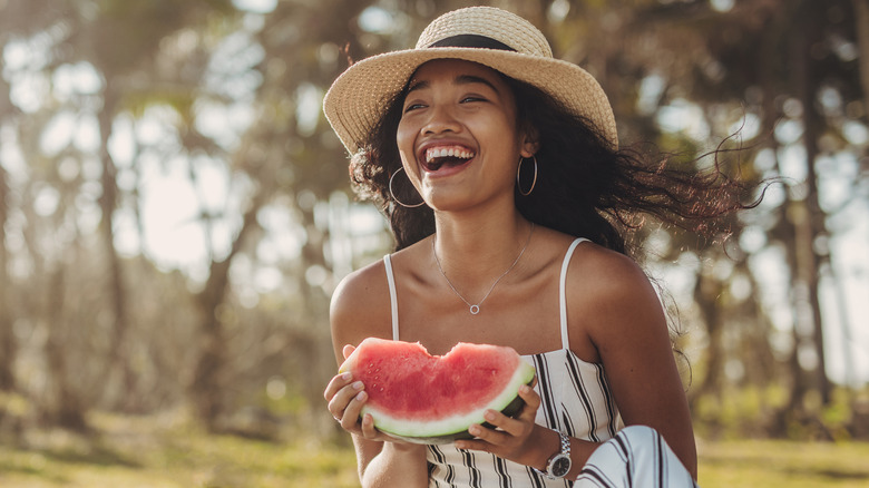 happy woman eating watermelon outside