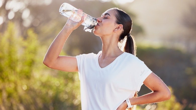 woman drinking water after a workout