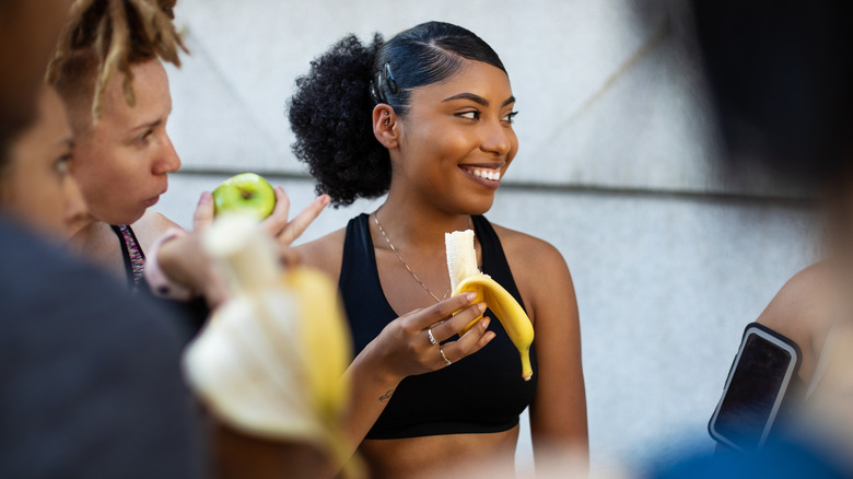 woman eating a banana after a workout