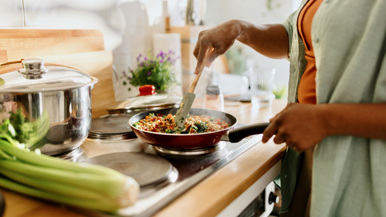 woman cooking quinoa on a stove