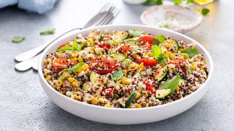 bowl of quinoa, vegetables, and herbs