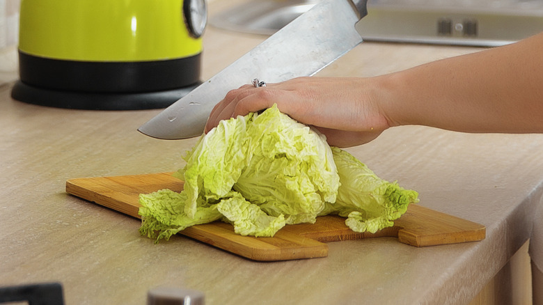 Woman chopping head of cabbage