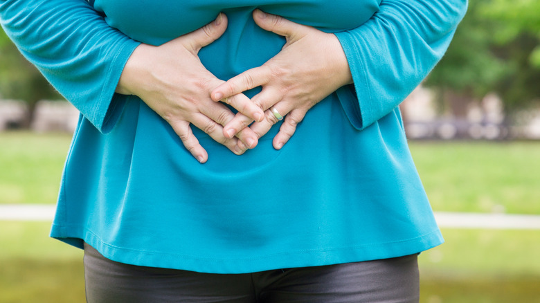 woman holding stomach in pain