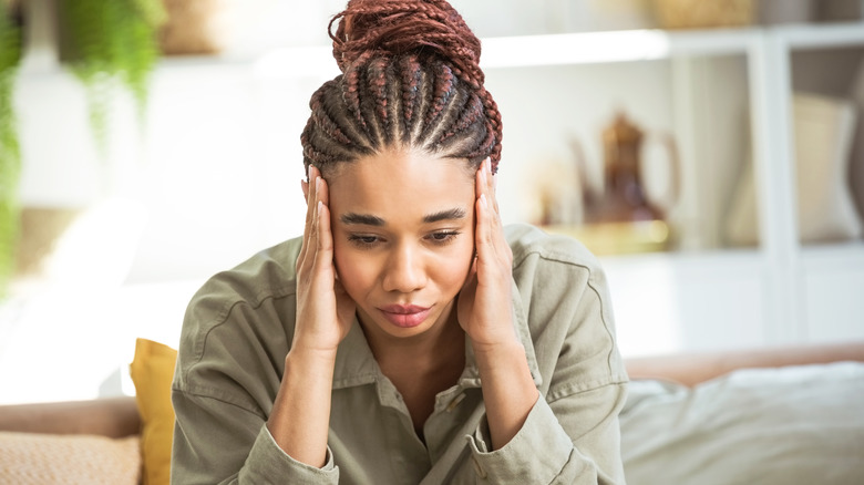 Stressed woman with hands on head