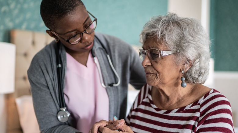 Healthcare professional tending to senior patient