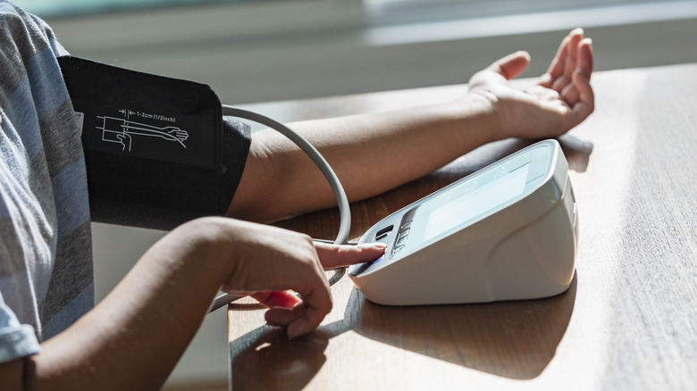 Person measuring blood pressure at home