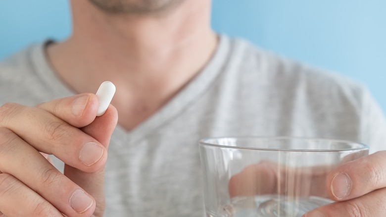 man taking medication for cholesterol