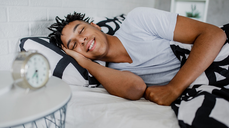 Smiling man asleep in bed