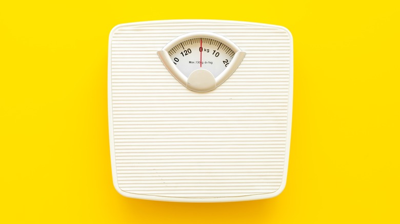 Bathroom scale against yellow background