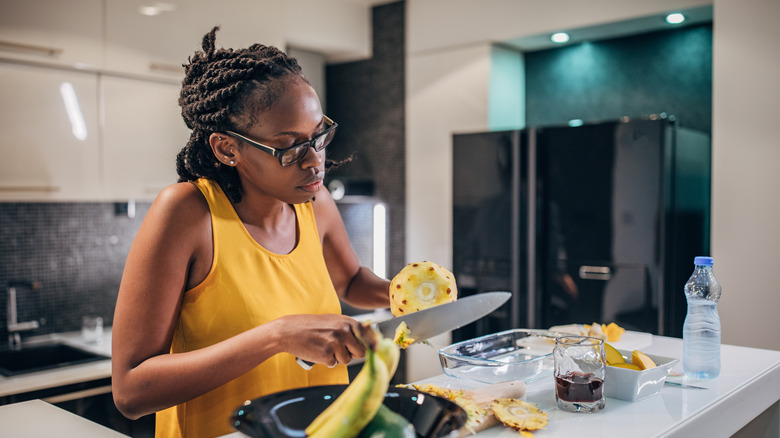 Woman cutting pineapple