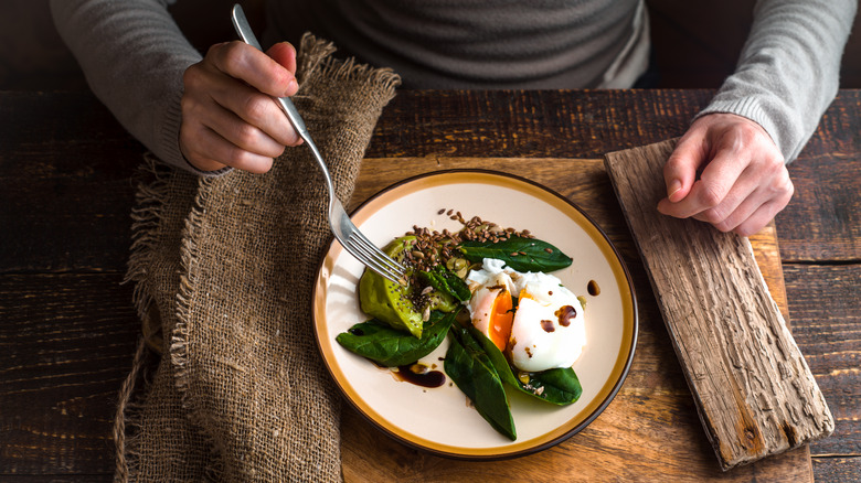 man eating meal featuring a poached egg