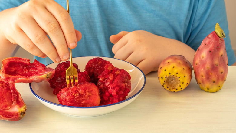 A child eating prickly pear fruit in bowl