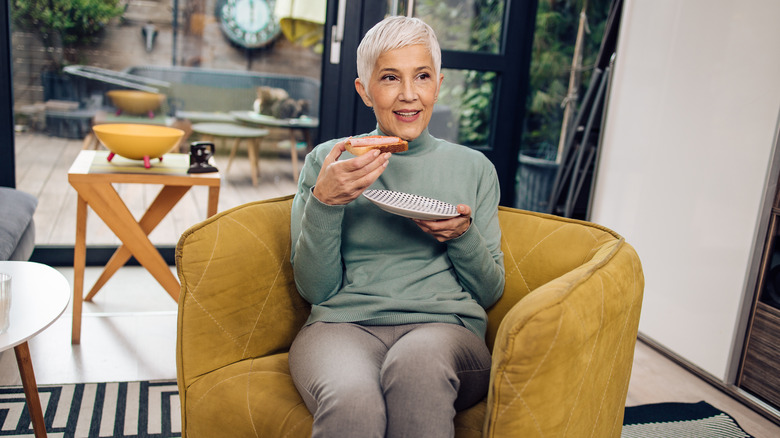 Elderly woman eating bread